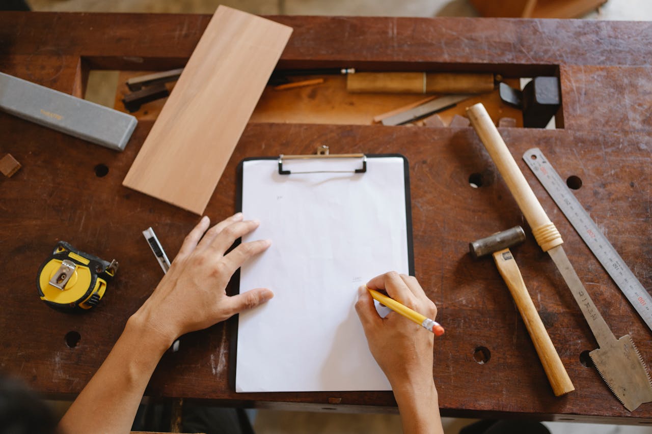 Crop artisan sketching on paper in workshop